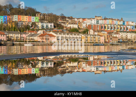 Colourful terraces of Cliftonwood in Bristol reflected in the waters of a puddle and those of the Floating Harbour, Bristol Stock Photo