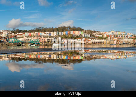 Colourful terraces of Cliftonwood in Bristol reflected in the waters of a puddle and those of the Floating Harbour, Bristol Stock Photo