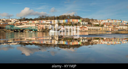 Colourful terraces of Cliftonwood in Bristol reflected in the waters of a puddle and those of the Floating Harbour, Bristol Stock Photo