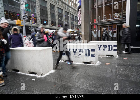 Tourists pass through barricades at the perimeter of Times Square in New York on Saturday, December 30, 2017. Security preparations are in place for New Year's eve in Times Square including the placement of rooftop observations teams and NYPD snipers. The weather for New Year's Eve is expected to be in the low teens as many stand outside for hours waiting for the Times Square Ball to drop.(© Richard B. Levine) Stock Photo