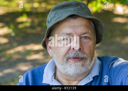Portrait of Caucasian senior man delighting while making selfie outdoors Stock Photo