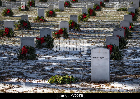 A fallen wreath on the grave of an Unknown US service member at a national cemetery. Stock Photo