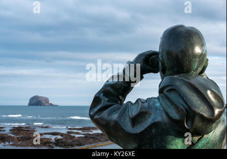 Life size statue, The Watcher, by Kenny Hunter, at Scottish Seabird Centre. Man looking at Bass Rock through binoculars, North Berwick, Scotland, UK Stock Photo