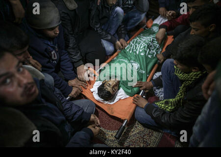 GRAPHIC CONTENT: Maghazi refugee camp, central Gaza Strip, 12 January 2018. Relatives and mourners attend the funeral of 16-year old Amir Abu Musaed in the The teenager was shot during clashes between Palestinians and Israeli forces along the Gaza border on Thursday. Photo: Wissam Nassar/dpa/Alamy Live News Stock Photo