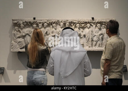 Abu Dhabi, UAE. 12th January, 2018. Visitors examine the displays in the Louvre Abu Dhabi in the UAE capital on 12 January 2018. The museum opened on Saadiyat Island in November 2017, with a collection based on items held by the Louvre in Paris, France. The building was designed by Jean Nouvel. Credit: Dominic Dudley/Alamy Live News Stock Photo