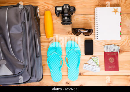objects travel on a wooden floor near a suitcase Stock Photo