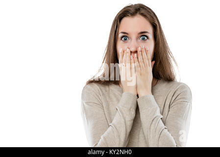 surprised young girl covers her mouth with her hands on a white background isolated Stock Photo