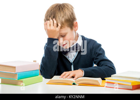 schoolboy at the table reading a book, shooting on a white background Stock Photo