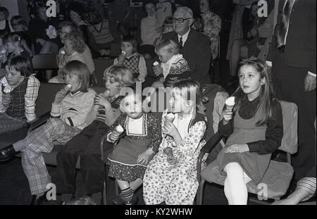 1970, historical, young children stting eating ice cream cornets at a christmas party. Stock Photo