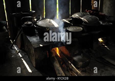 Cooking pots and pans on the fire in a dark kitchen, Ba Be National Park, north Vietnam Stock Photo