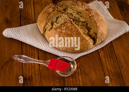 Traditional Irish Soda Bread Made For St. Patricks's Day, Pastry Brush And Oil Served On Wooden Table Stock Photo