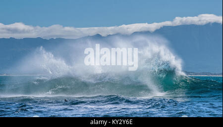 Sea landscape.  Clouds sky, waves with splashes, mountains silhouettes. False bay. South Africa. Stock Photo