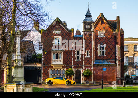 Yellow Lamborghini parked outside grand old house on Chequer Square next to the Norman tower & facing the Great churchyard, Bury St. Edmunds, Suffolk, Stock Photo