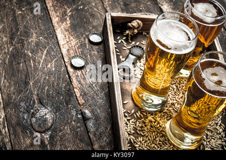 Glasses with fresh beer on an old tray. On a wooden background. Stock Photo