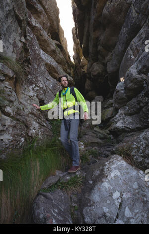 Hiker walking down on rocks with backpack Stock Photo