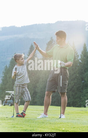 Father and son giving high five to each other Stock Photo
