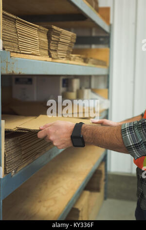 Man arranging cardboard in shelf Stock Photo