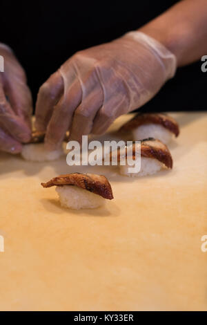 Chef preparing sushi on a chopping board Stock Photo