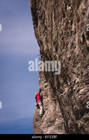 Rock climber reaching on the cliff top Stock Photo