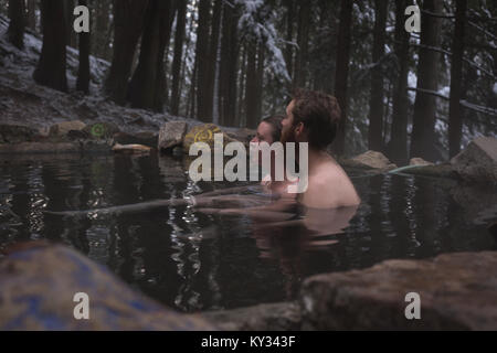 Thoughtful couple relaxing in hot spring Stock Photo
