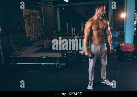 Muscular man exercising with dumbbells Stock Photo