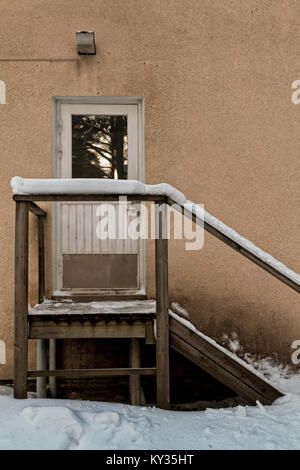 The snow has covered the wooden stairs leading to the door of an old building in the Northern Finland. Stock Photo