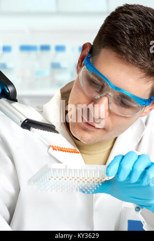 Young biologist sets DNA sequencing reaction with multichannel pipette Stock Photo