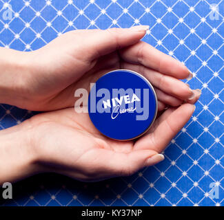 DORKOVO, BULGARIA - FEBRUARY 10, 2017:  Nivea Cream three jar on soft human hand background. Nivea brand owned by the German company Beiersdorf AG. Stock Photo