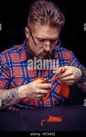 Leather Tanner creates a new leatherwork at the tanner shop Stock Photo