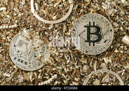 Golden metal coin as symbolic version of Bitcoin on a background of metal shavings . Cryptocurrency and new digital payment system concept. Stock Photo