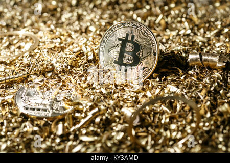 Golden metal coin as symbolic version of Bitcoin on a background of metal shavings . Cryptocurrency and new digital payment system concept. Stock Photo