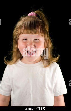 Excited laughing child wearing white t-shirt looking at you isolated on black Stock Photo