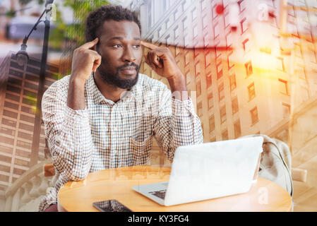 Serious brunette male being deep in thoughts Stock Photo