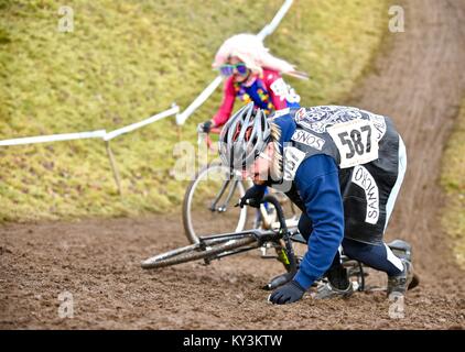 Cyclocross racers traversing diverse terrain, over obstacles, in rainy conditions while dressed in halloween costumes in October of 2016 in Bend, Oregon. Stock Photo