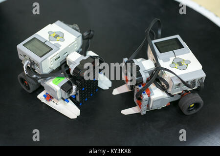 technology, invention, machining concept. close up of two robots that are placed on the black surface of special testing platform, they are equipped w Stock Photo