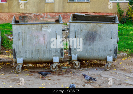 Two garbage bins in a park, one for paper, one for cans and one for unrecyclable trash. can garbage Stock Photo