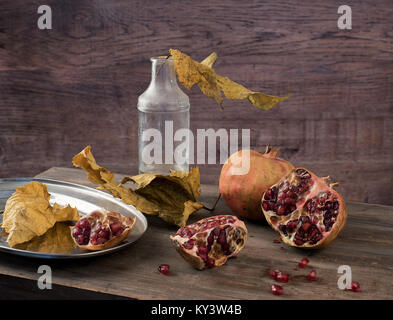 retro still life with pomegranate and dry leaves Stock Photo