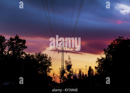 Power-lines silhouetted by sky at sunset The silhouette of the evening electricity transmission Stock Photo