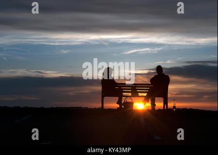 Couple enjoying the evening sunset on Aberaeron seafront, Ceredigion, Wales, UK Stock Photo
