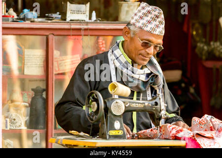 Nepali tailor sews on the street. Often to see the people working on the street, as in Nepal. Kathmandu, Nepal Stock Photo