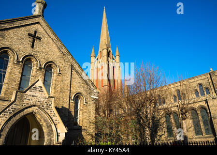 Amongst rows of red and white brick terrace houses is William Rangers 1840 Victorian Gothic church of St John the Evangelist. Bury St Edmunds, Suffolk Stock Photo