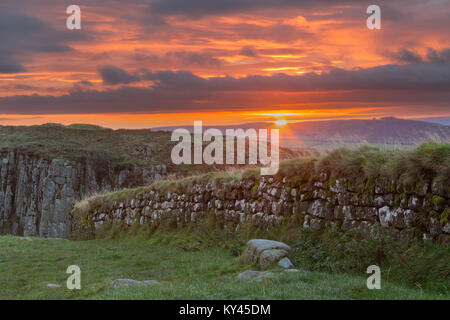 Hadrian's Wall: the view to the south-east at dawn, just as the sun rises, from Steel Rigg, looking over a section of the Wall and on to Peel Crags. Stock Photo