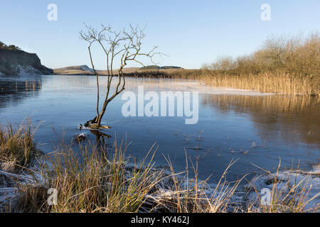 Hadrian's Wall: Crag Lough, frozen, in the grip of winter, on a beautiful sunny day. The view looking west towards Steel Rigg and Winshield Crags. Stock Photo