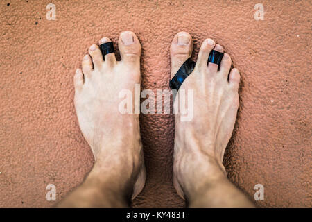 From above damaged feet of freediving man swimming with fins. Stock Photo