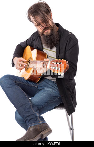 Young bearded man playing an acoustic guitar isolated over white background Stock Photo