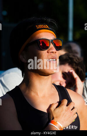 Sussex, UK. A young Asian person wearing reflective sunglasses recites the Tough Mudder mantra before taking part in an event. Stock Photo