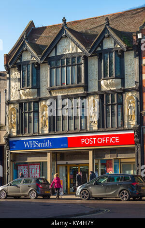 Famous facade above the WH Smith & Post Office, top panel depicts King Canute demonstrating his fallibility to hold back the tide. Bury St Edmunds, UK Stock Photo