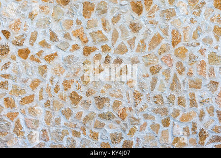 Background from a rough beige natural stone wall Stock Photo