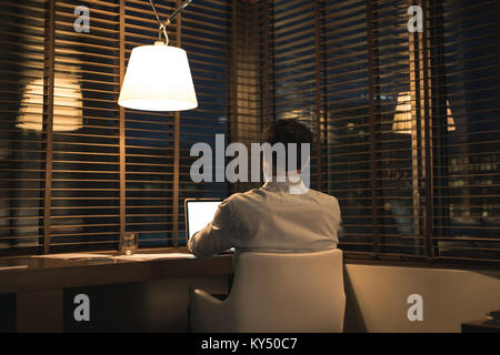 Businessman using laptop at desk Stock Photo