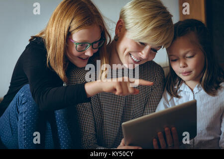 Mother and her kids using digital tablet at home Stock Photo